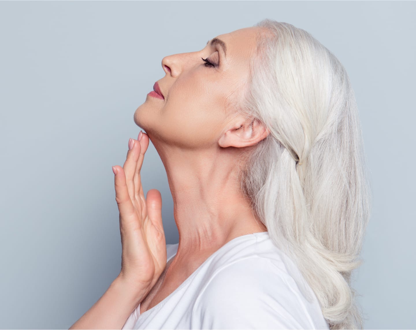 Older woman looking up, touching under her chin